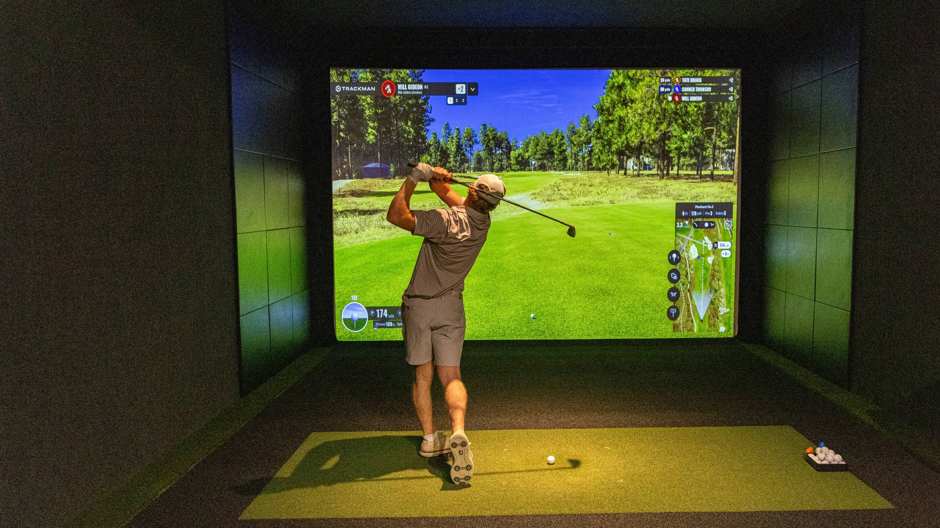 A player using a golf simulator for practice.