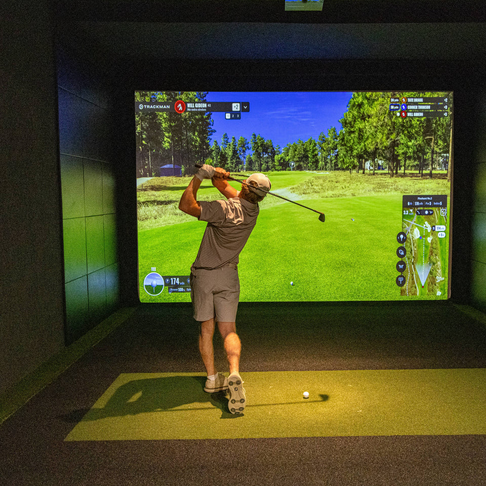 A player using a golf simulator for practice.