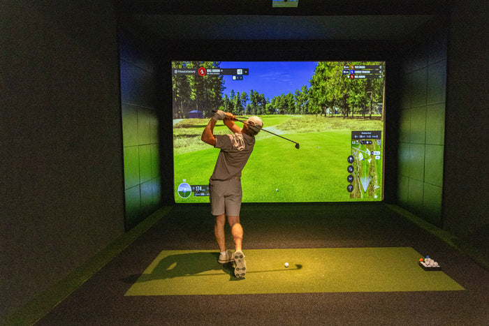 A player using a golf simulator for practice.