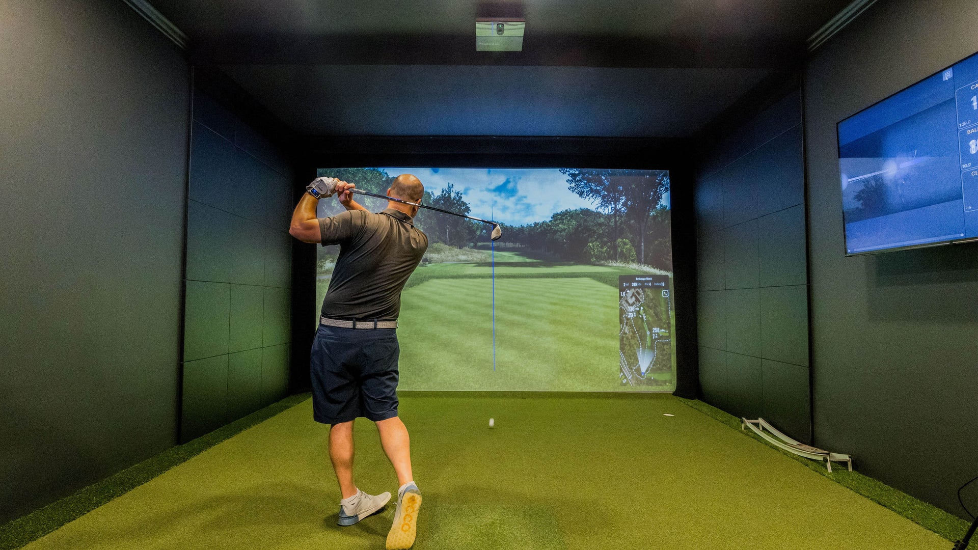 Golf Simulator with a Golfer hitting on a Trackman iO
