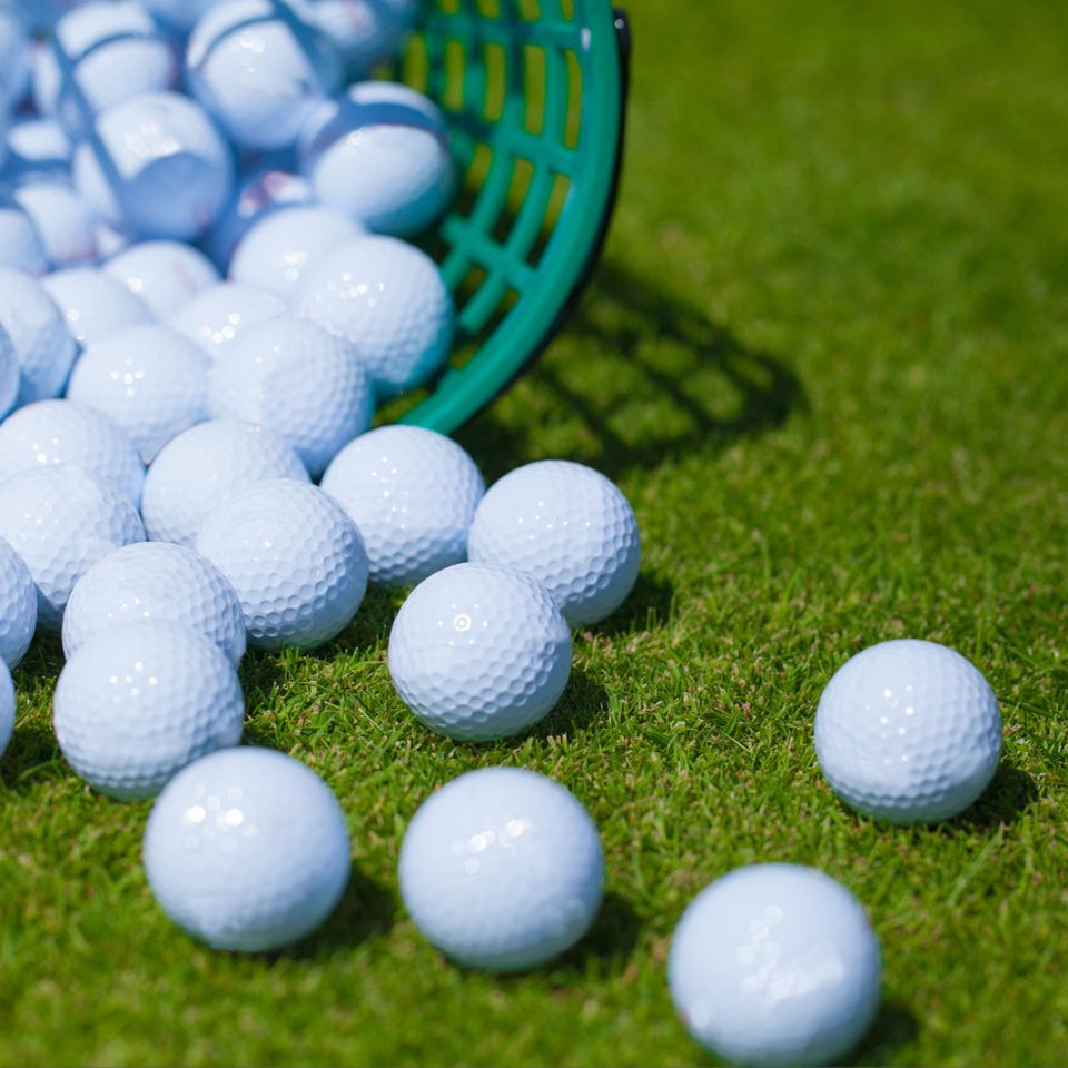 Golf Balls poured out on a driving range