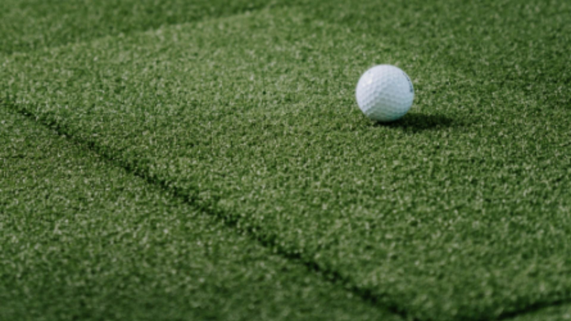 Up close image of SIGPRO Softy Golf Mat with golf ball resting on top.