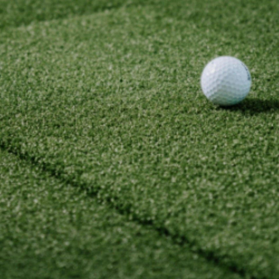 Up close image of SIGPRO Softy Golf Mat with golf ball resting on top.