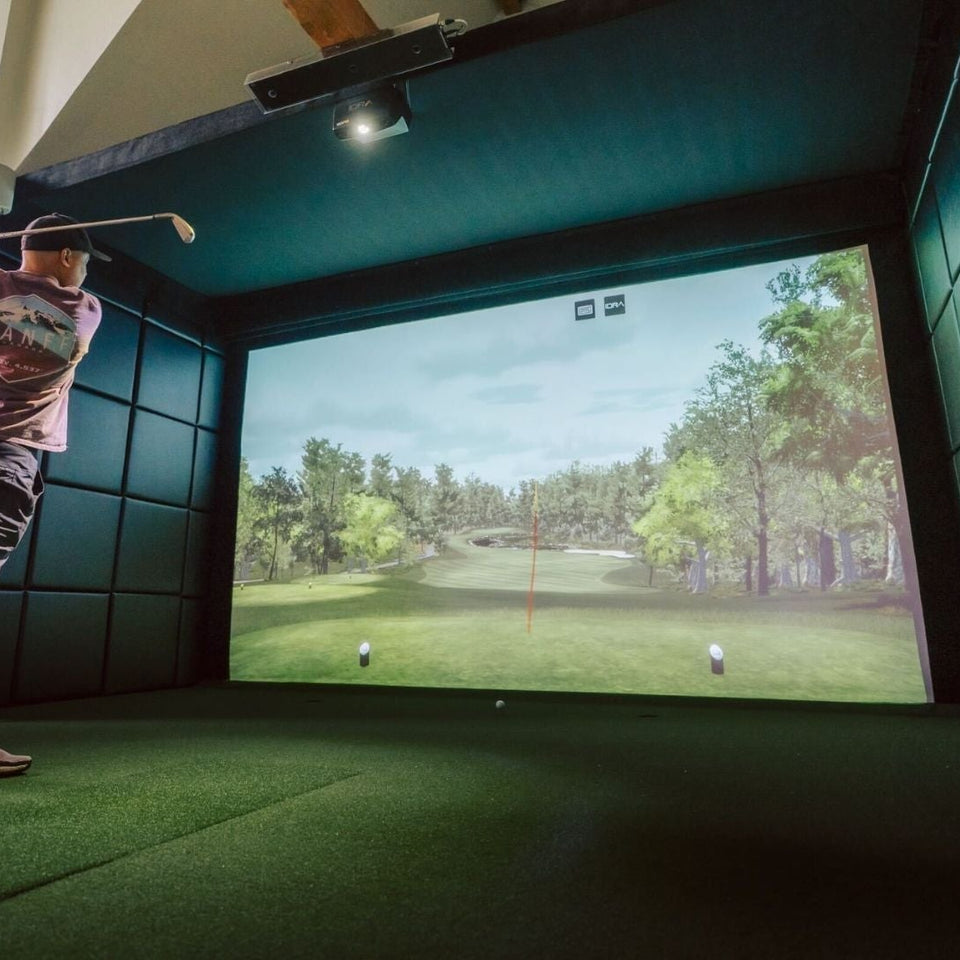 Golfer swinging a club on a golf simulator