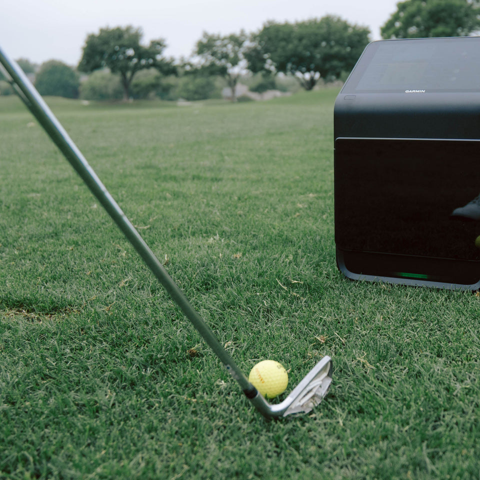 Square golf launch monitor on turf.