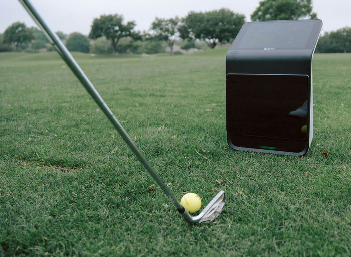 Square golf launch monitor on turf.
