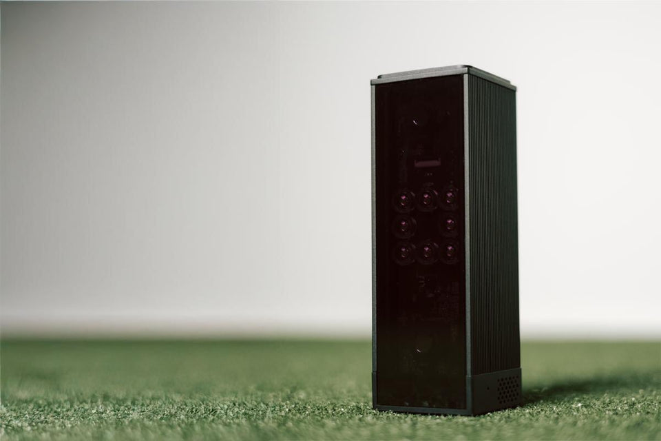 Square golf launch monitor on turf.