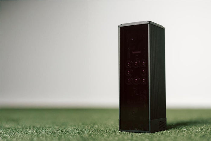 Square golf launch monitor on turf.