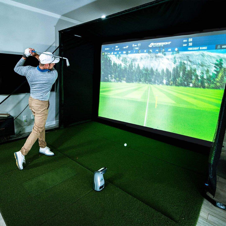 Golfer hitting into SIG Enclosure with GC3 launch monitor reading the golf shot and showing the data on the enclosure screen.