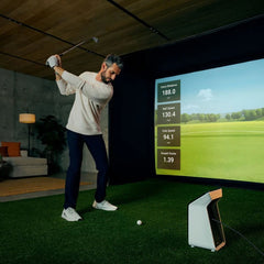 Garmin Approach R50 golf simulator and launch monitor with golfer swinging.