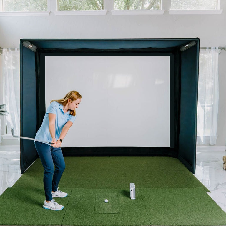 women hitting a golf ball on the sig10 golf simulator enclosure