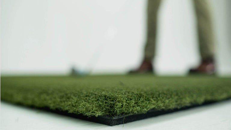 Golfer standing on hitting mat