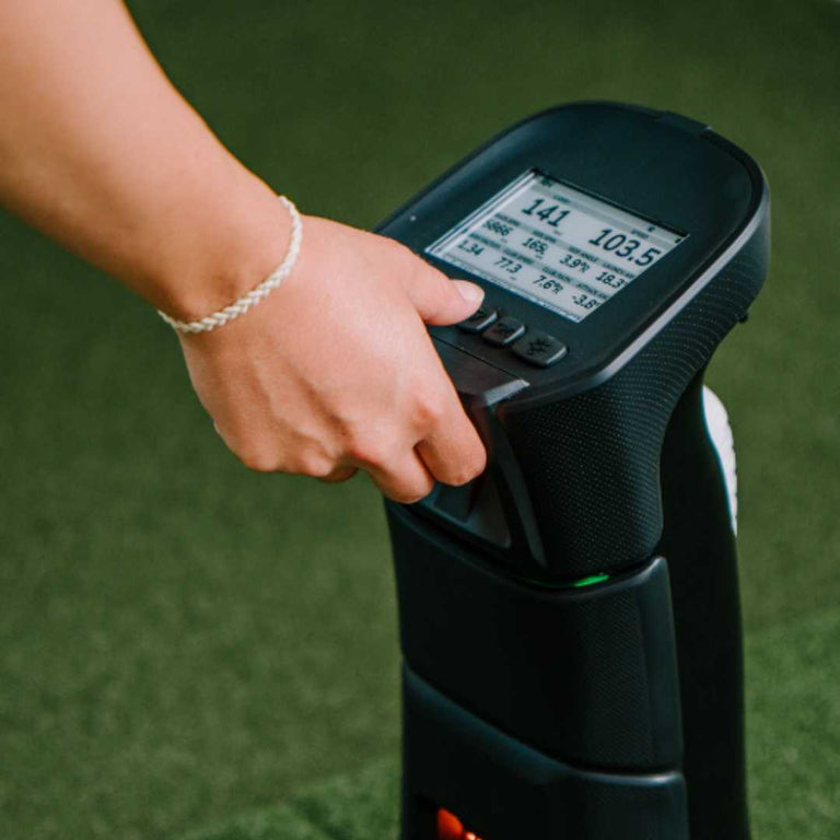 Uneekor EYE MINI Launch Monitor with data on display screen.