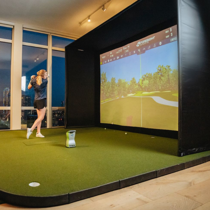 SIG12 enclosure with golfer hitting into screen with Foresight Sports GCQuad launch monitor