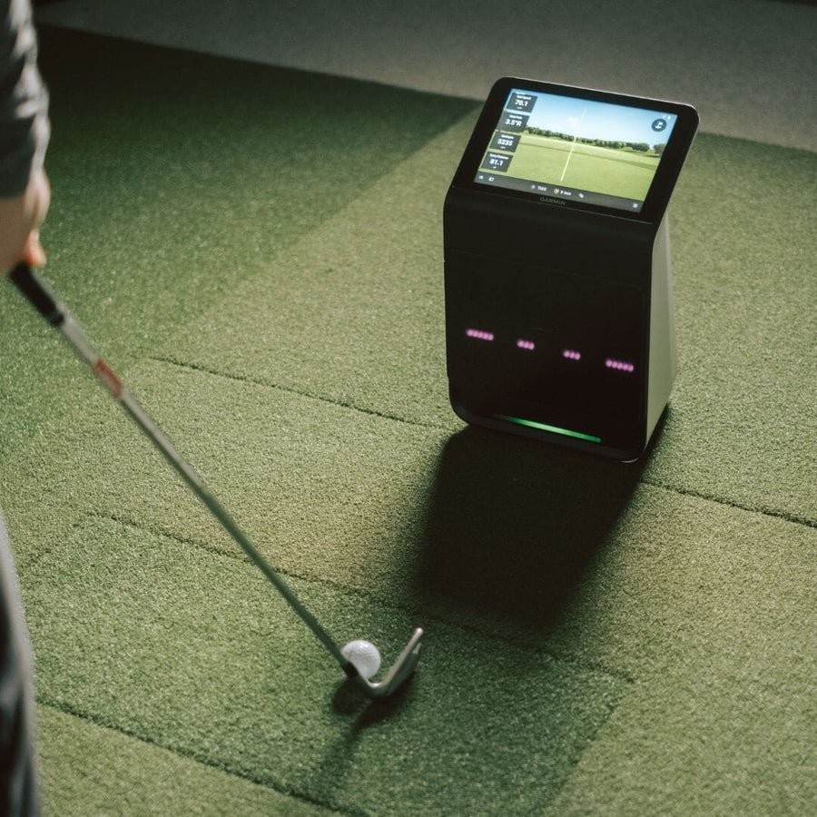 Garmin Approach R50 launch monitor beside a golfer and club